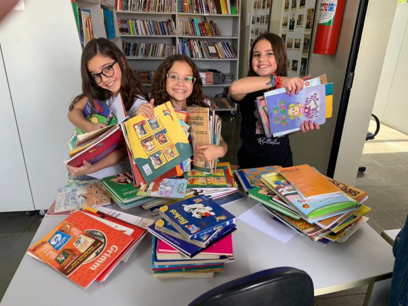 Alunos fazem a lição de casa na biblioteca.